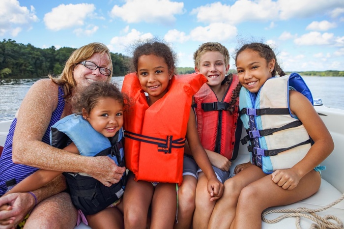 Family in Life jackets on a boat on a lake
